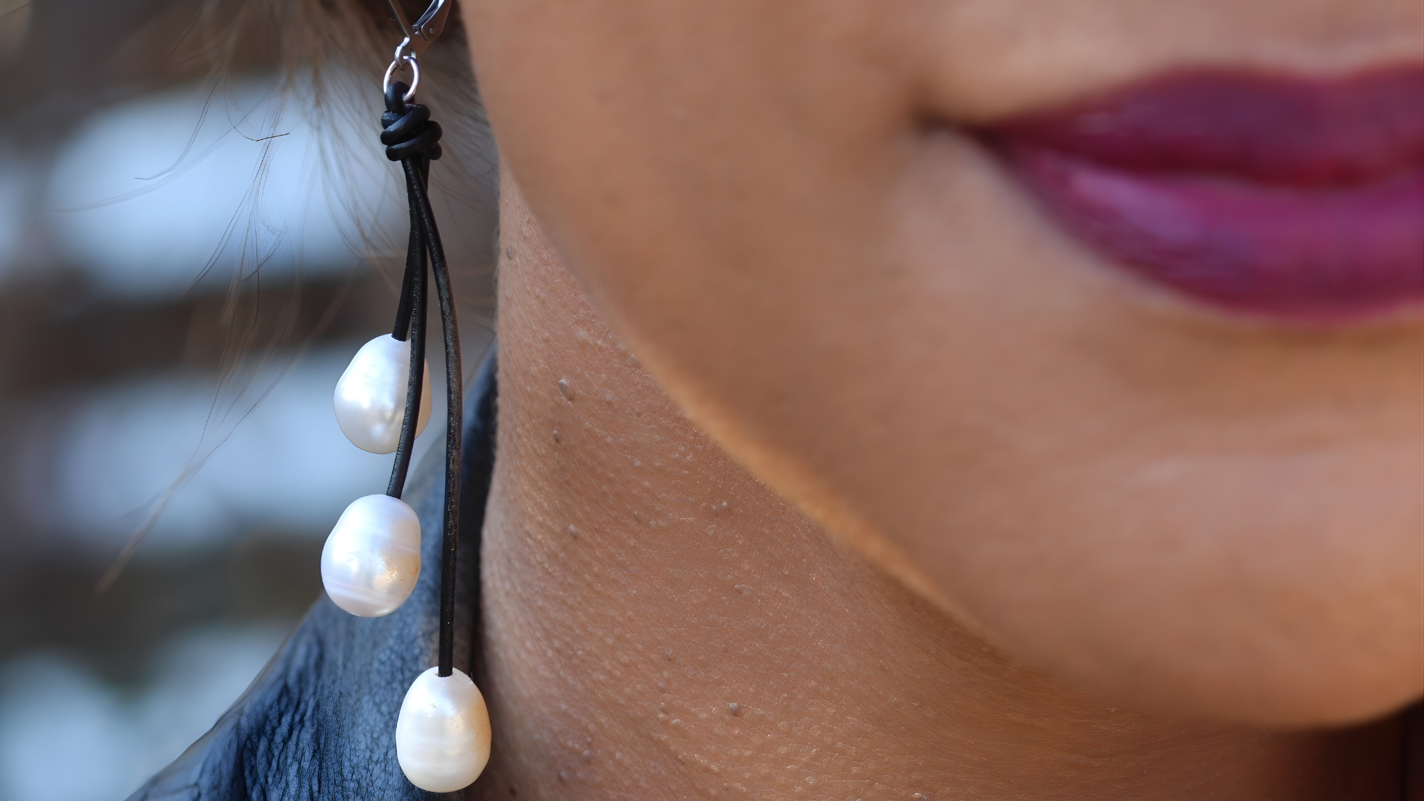Close-up of a pearl earring worn by a person with blurred background