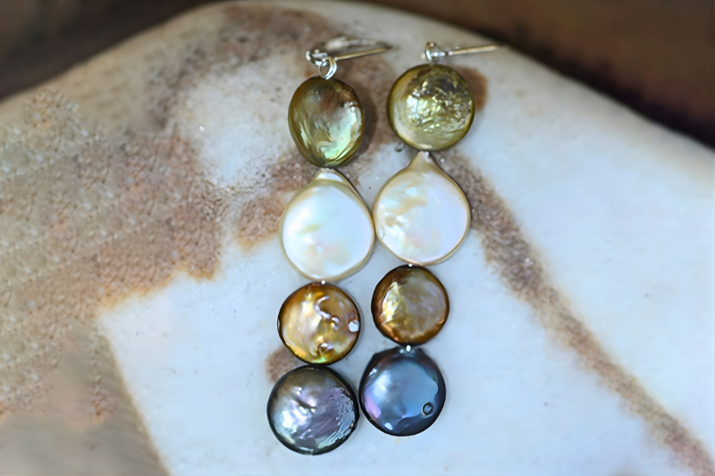 Pair of earrings with multicolored stones on a textured surface